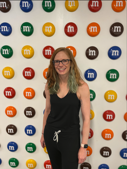 Mars Associate Allison Faig standing in front of an M&M's background