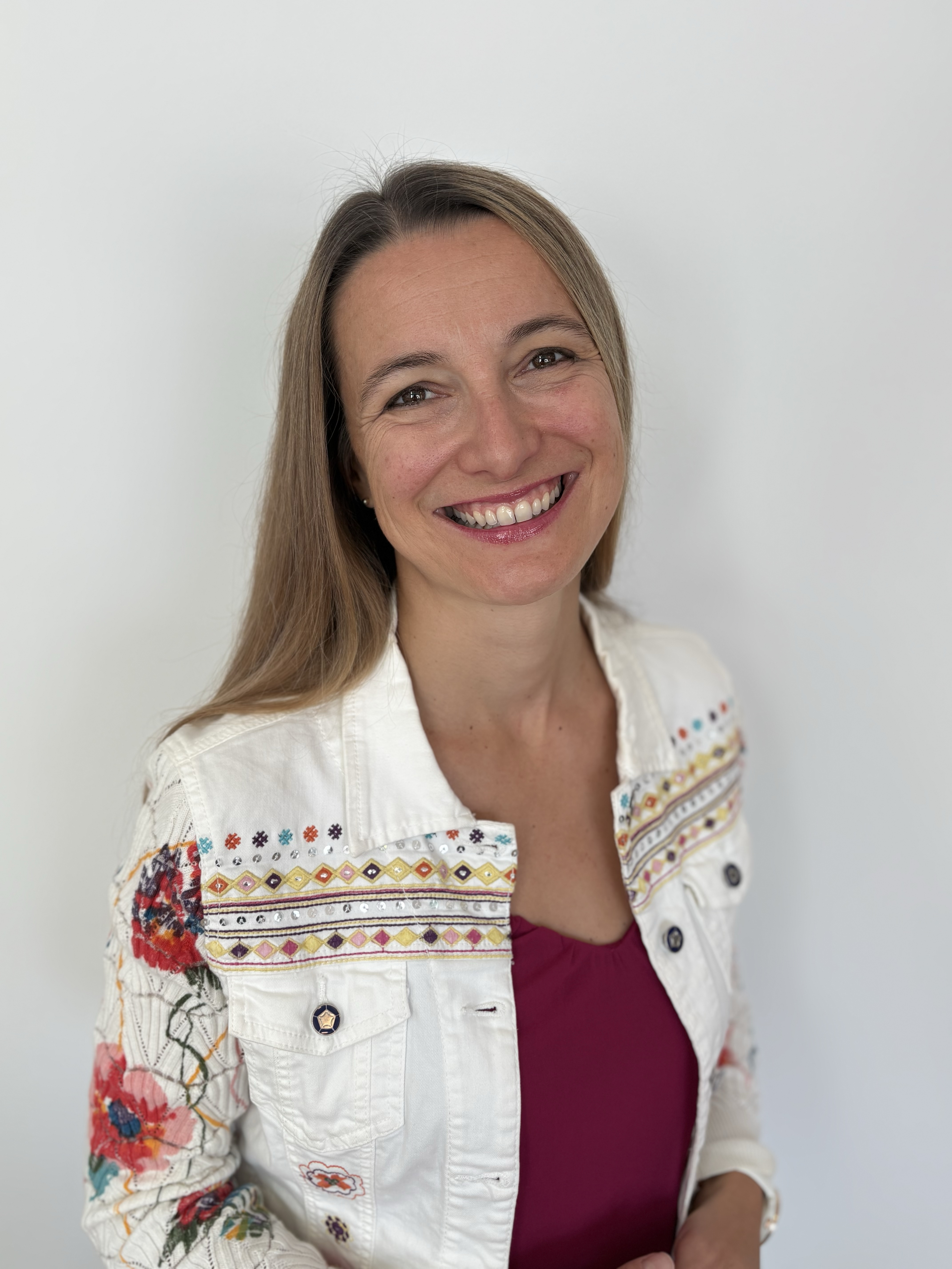 Eine Frau, die freundlich in die Kamera lächelt