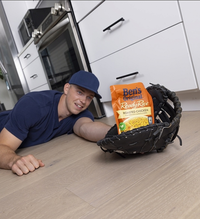 Baseball player Ben Rice catching a package of Ben's Original rice