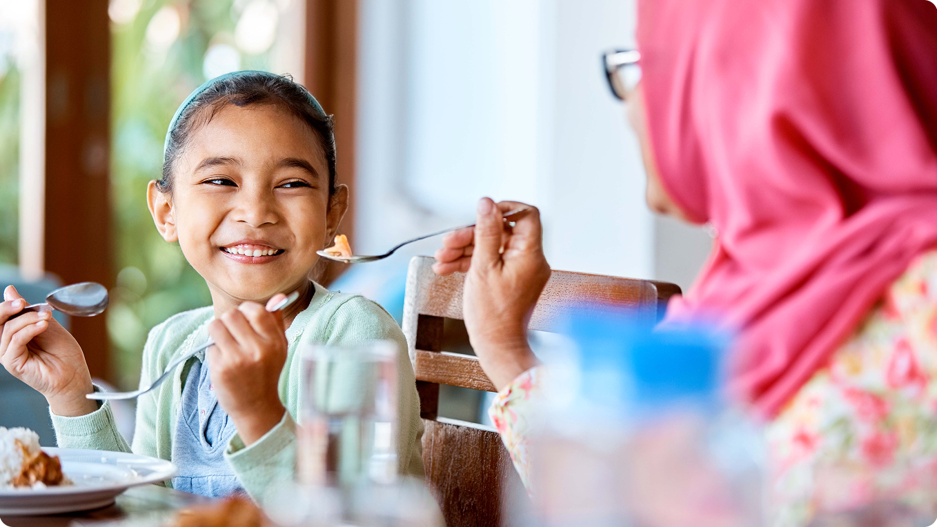 Girl eating with her mom