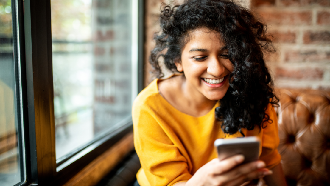 Smiling young woman using a mobile phone