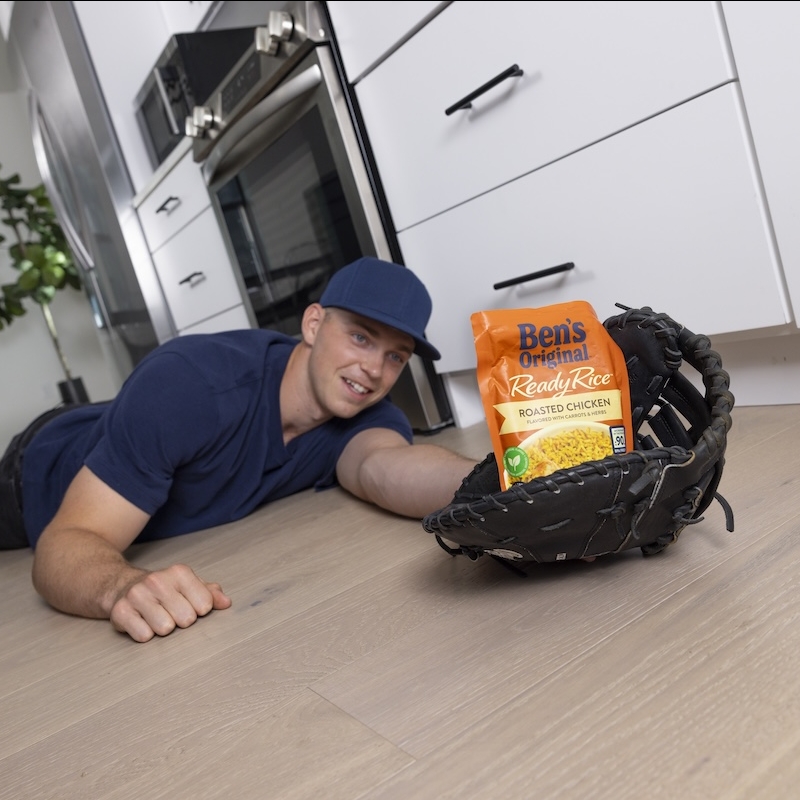 Baseball player Ben Rice catching a package of Ben's Original rice