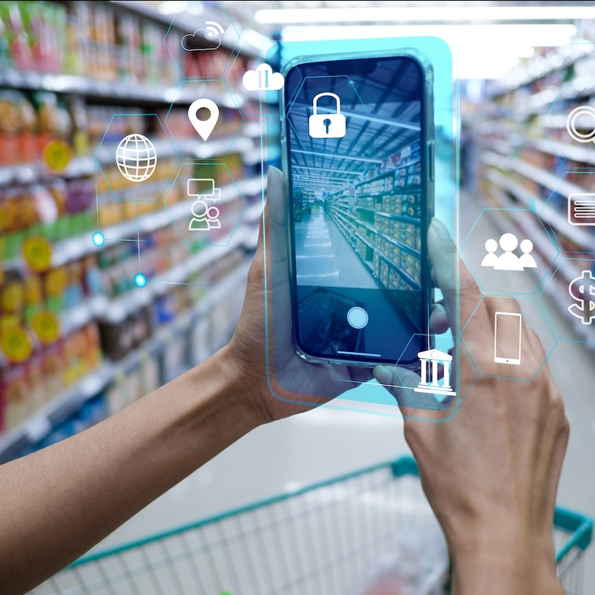 Person holding a smartphone in a grocery aisle