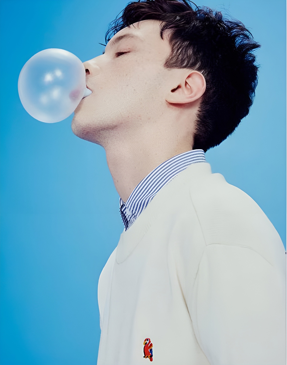 Мужчина надувает пузырь из жевательной резинки