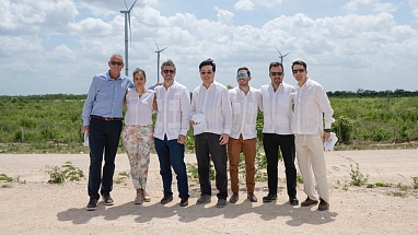 A group of people with a wind turbine behind