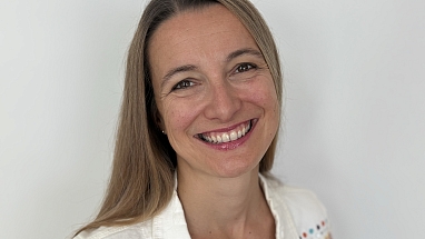 Eine Frau, die freundlich in die Kamera lächelt