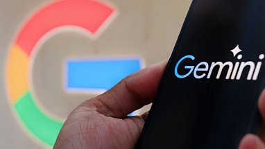 The Google logo and a hand holding a smartphone with Google Gemini on screen.