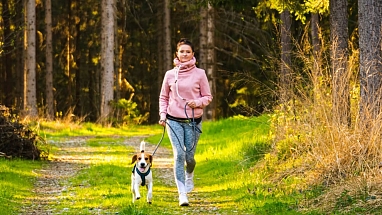 Woman trail running with a dog 