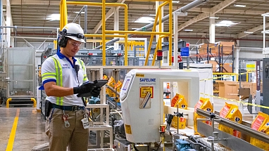 Man stood before factory line for Pet care 