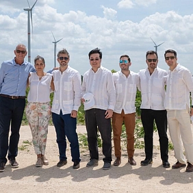 A group of people with a wind turbine behind