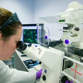 Scientist looking through a microscope