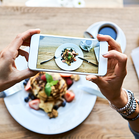 A women takes a picture of her delicious meal