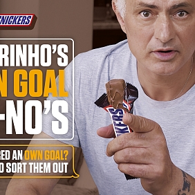 Jose Mourinho holding a SNICKERS in the brand's latest AI-powered campaign
