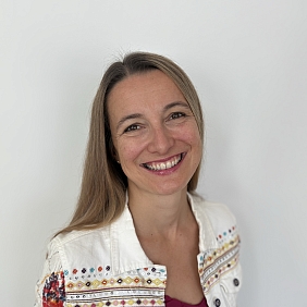 Eine Frau, die freundlich in die Kamera lächelt