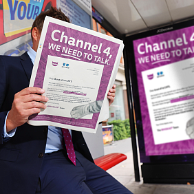 A man sitting at a bus stop, reading Whiska's open letter to Channel 4.