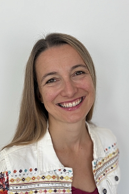 Eine Frau, die freundlich in die Kamera lächelt