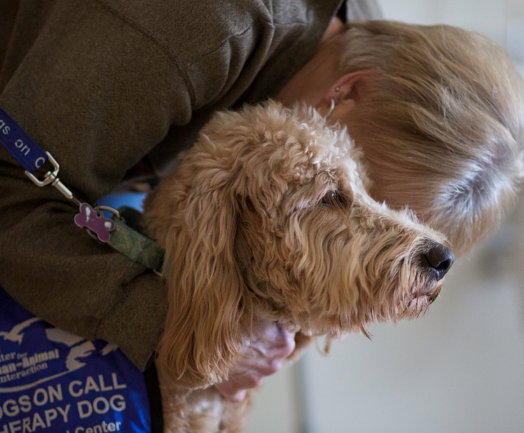 Senior woman hugging VCU therapy dog