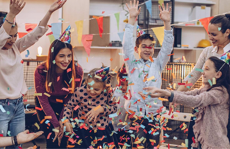 Family friends playing in confetti and celebrating their friend’s birthday.